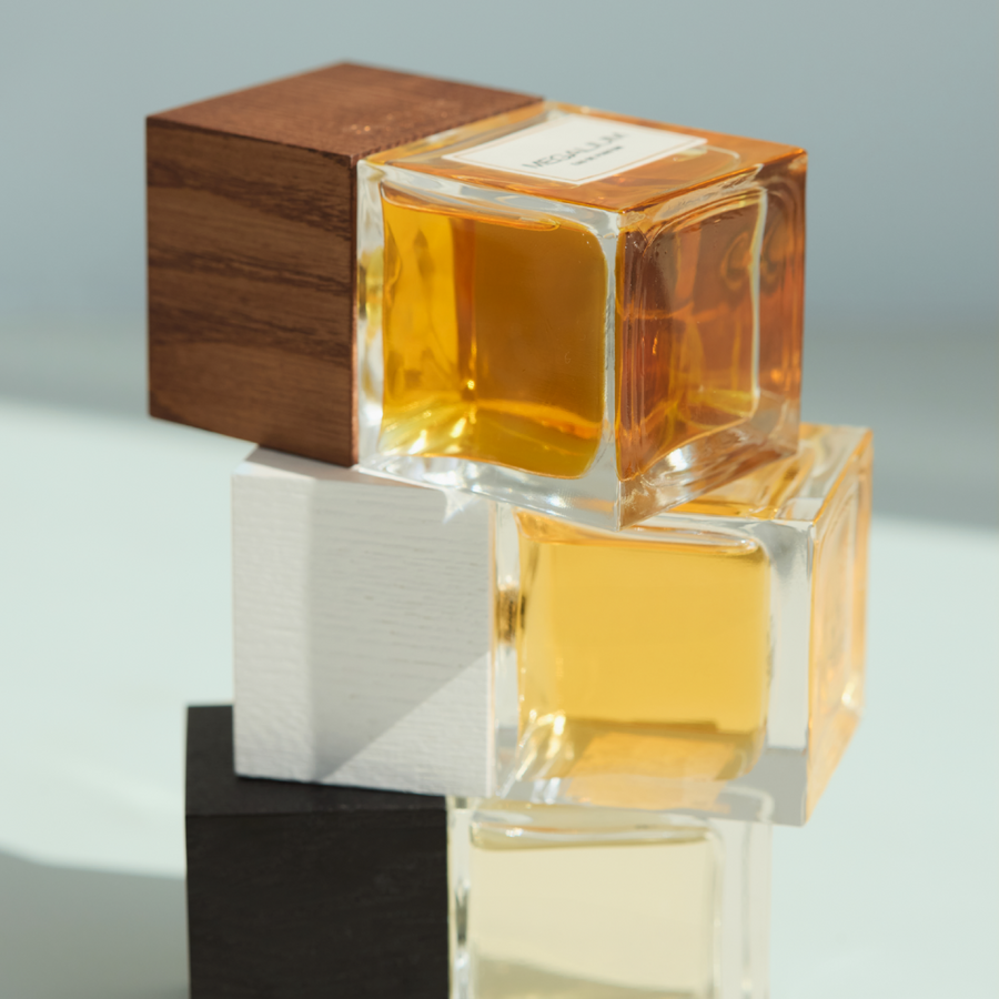 Carner Barcelona perfume bottles stacked on wood